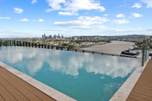 a swimming pool on top of a building with a view of a beach at Cozy 1BR Retreat in Hamilton Near River and Dining in Brisbane