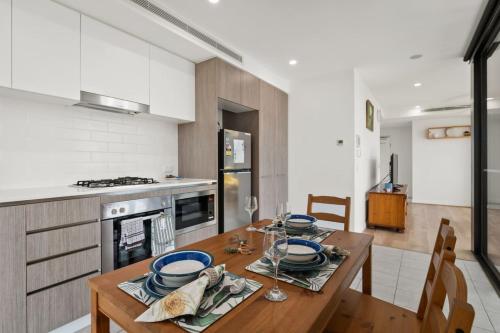 a kitchen with a wooden table with blue dishes on it at Cozy 1BR Retreat in Hamilton Near River and Dining in Brisbane