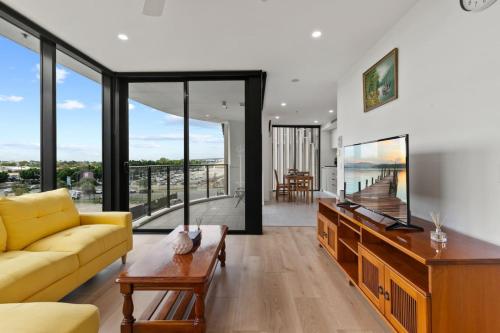 a living room with a yellow couch and a table at Cozy 1BR Retreat in Hamilton Near River and Dining in Brisbane