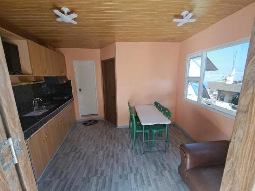 a kitchen with a table and chairs and a window at Apo Licz Transient 3C in Baguio