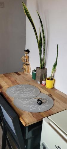 a wooden table with a cutting board on it with plants at Alborada in San Fernando del Valle de Catamarca