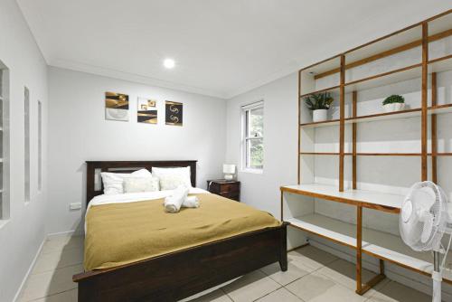 a bedroom with a bed and a book shelf at Spacious 5BR Retreat with Balcony Near Hotspots in Springwood