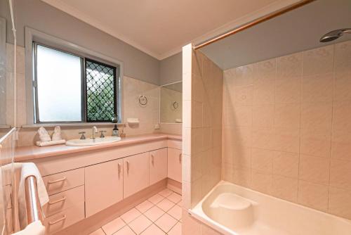 a bathroom with a tub and a sink and a bath tub at Spacious 5BR Retreat with Balcony Near Hotspots in Springwood