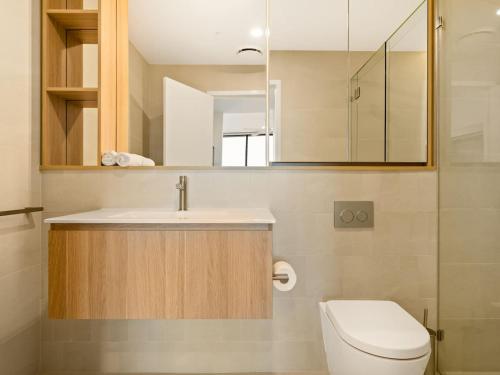 a bathroom with a sink and a toilet and a mirror at 2BR West End Apt with Parking Walk to Convention Ctr in Brisbane