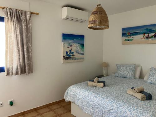 a bedroom with a bed with two pillows on it at Beach house with the heated pool next to Rocky Point in Corralejo