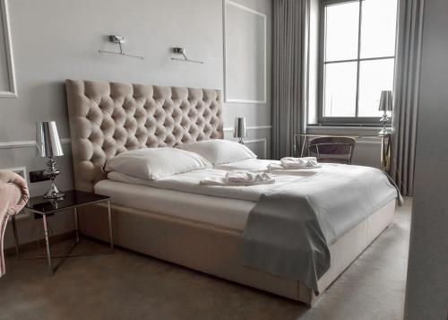 a bedroom with a large bed with a large headboard at Apartamenty Atmosfera Bytów in Bytów