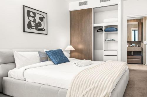 a bedroom with a large white bed and a couch at Modern 1BR Apartment in the Heart of Brisbane City in Brisbane