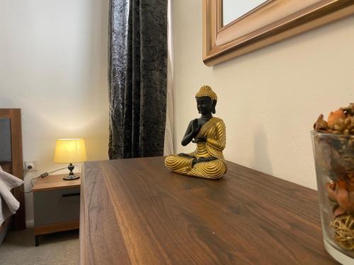 a statue of a buddha sitting on a table at Sea Breeze Retreat - Comfort Apartments in the Heart of Sliema in Sliema