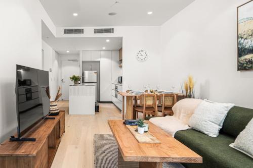 ブリスベンにあるModern 1BR Apt in Prime Queens Wharf Locationのソファとテーブルのあるリビングルーム