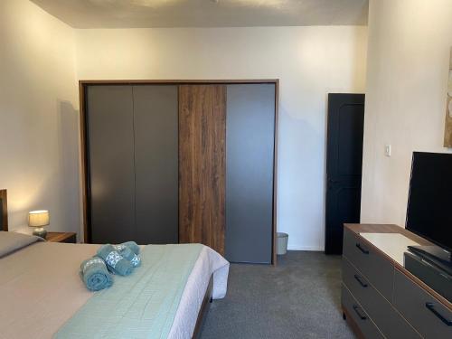 a bedroom with a bed and a dresser with a television at Sea Breeze Retreat - Comfort Apartments in the Heart of Sliema in Sliema