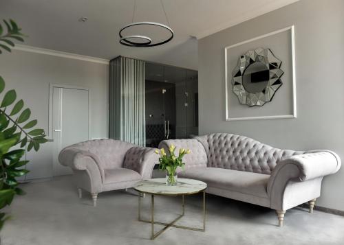 a living room with two couches and a table at Apartamenty Atmosfera Bytów in Bytów