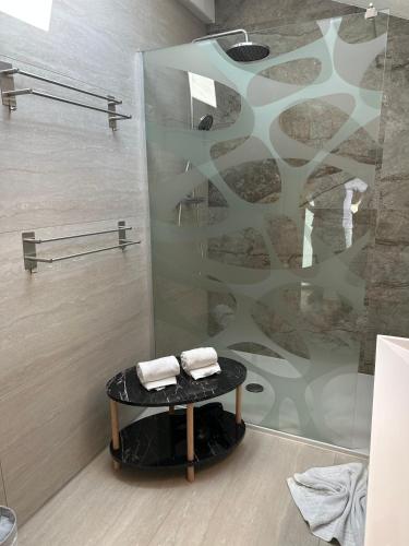a bathroom with a shower and a table with towels at Deluxe Apart Bader in Ehrwald