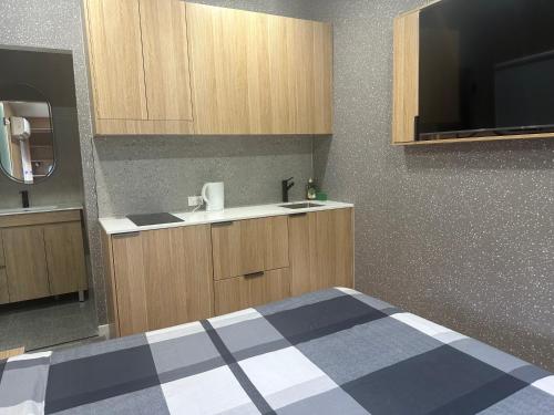 a bedroom with a bed and a sink and cabinets at Sydney Premium Studio Renovated 2025 in Sydney