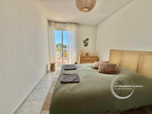 une chambre avec un grand lit et une fenêtre dans l'établissement La Frégate - Grand Appartement avec vue sur la mer - Piscine, à Carqueiranne