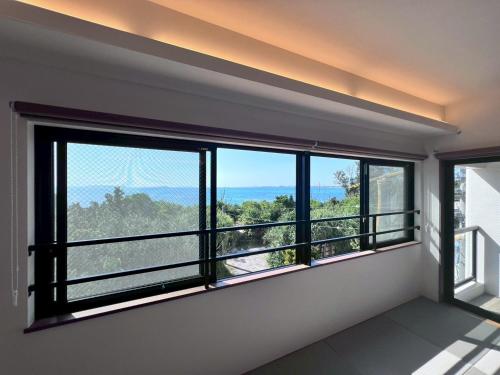 a room with a large window with a view at LAGUNA OKINAWA Beachfront YAKA in Kin
