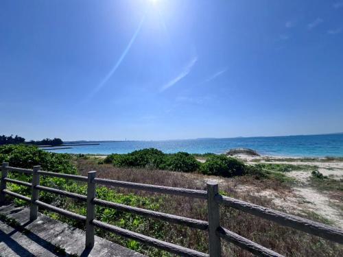 a wooden fence next to a beach with the ocean at LAGUNA OKINAWA Beachfront YAKA in Kin