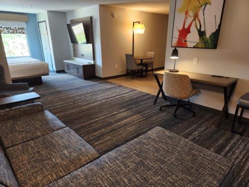 a living room with a desk and a couch at La Quinta by Wyndham Warner Robins - Robins AFB in Warner Robins