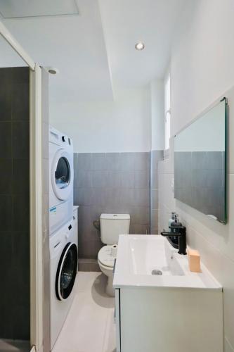 une salle de bain avec une machine à laver et un lavabo dans l'établissement Les Palmiers Wilson - Apt 3 Pers - 500 m beaches, à Antibes