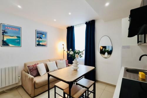 un salon avec un canapé et une table dans l'établissement Les Palmiers Wilson - Apt 3 Pers - 500 m beaches, à Antibes