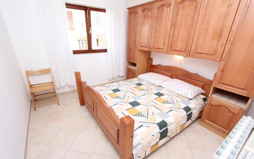 Schlafzimmer mit einem Bett und einem Holzschrank in der Unterkunft Apartments Maruchita in Rovinj