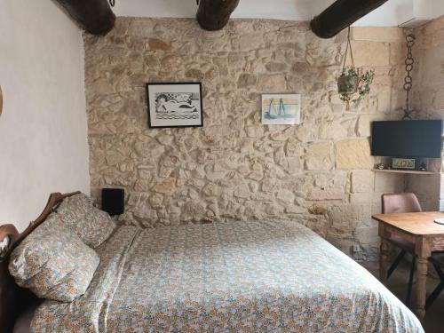 une chambre avec un lit et un mur en pierre dans l'établissement Charmant studio Vieux Port, à Marseille