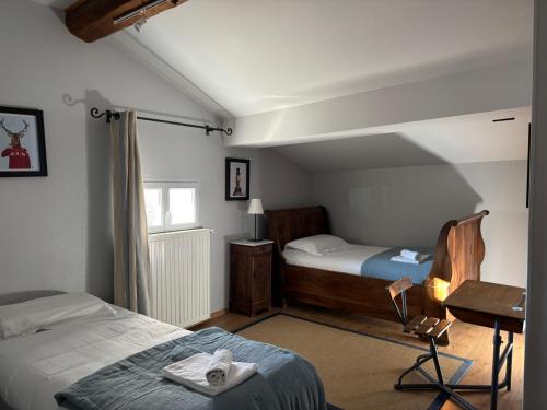 une chambre avec deux lits et un bureau et une fenêtre dans l'établissement La Bastide Saint Etienne, à Cournanel