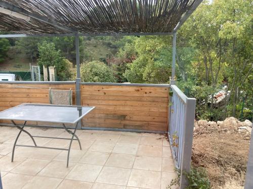 d'une terrasse avec une table et une clôture. dans l'établissement JOLI T2 a ROQUEVAIRE, à Roquevaire