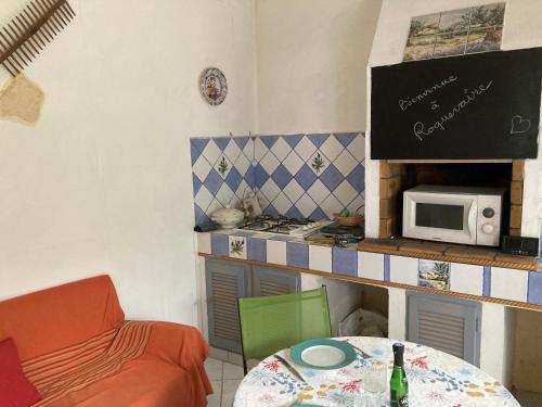 une petite cuisine avec une table et un micro-ondes dans l'établissement JOLI T2 a ROQUEVAIRE, à Roquevaire