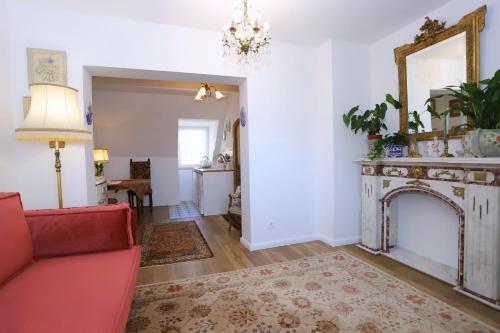 a living room with a fireplace and a red couch at Apartament Eviva l'arte! in Boguszów-Gorce