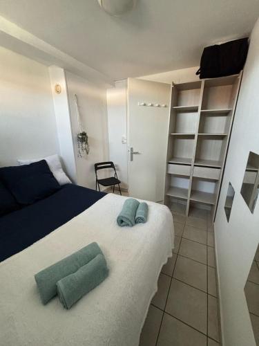 une chambre avec un lit avec deux serviettes dessus dans l'établissement De l'ancre à la criée hyper centre Dunkerque, à Dunkerque
