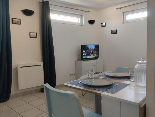una sala da pranzo con un tavolo con sedie e una televisione di Offre Novembre De l'ancre à la criée hyper centre Dunkerque a Dunkerque