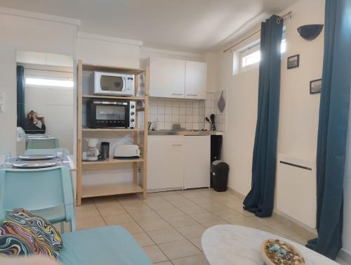 una cucina con mobili bianchi e una donna in una stanza di Offre Novembre De l'ancre à la criée hyper centre Dunkerque a Dunkerque