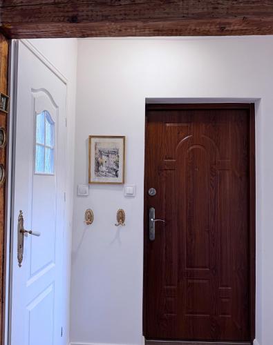 a wooden door in a room with a white wall at Apartament Eviva l'arte! in Boguszów-Gorce