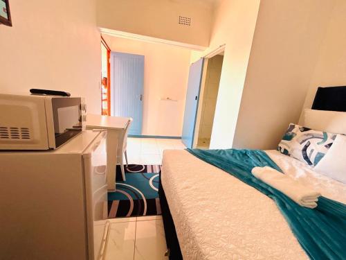 a small room with a bed and a microwave at Executive Accommodation Bellville 2 in Cape Town