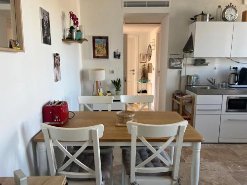 une cuisine et une salle à manger avec une table et des chaises en bois dans l'établissement appartement maison de village, à Cagnes-sur-Mer