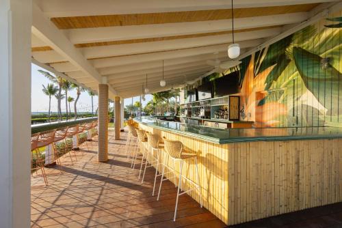 a restaurant with a bar with chairs on a patio at Hawks Cay Resort in Marathon