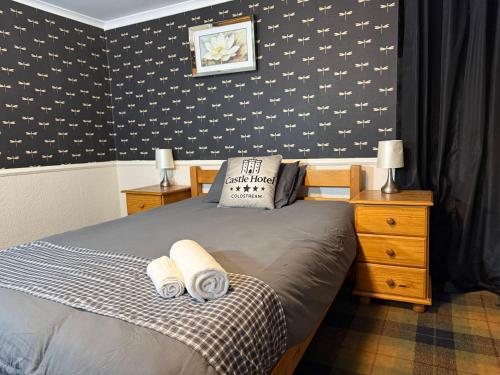 a bedroom with a bed with two towels on it at Modern Rooms with SELF Check-In The Castle, Coldstream in Coldstream