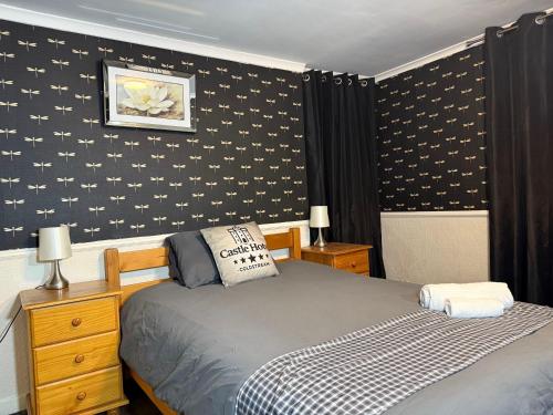 a bedroom with a bed and a black and white wall at Modern Rooms with SELF Check-In The Castle, Coldstream in Coldstream