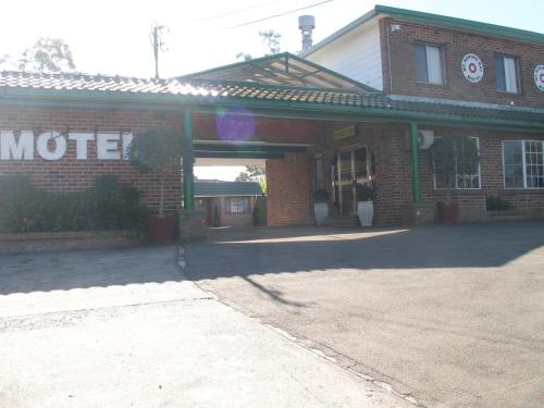 a brick building with a sign that reads motel at Mt Kuring-Gai Motel in Mount Kuring-Gai