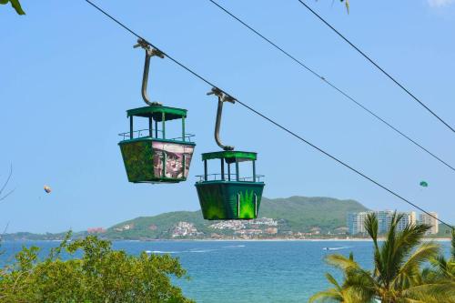 two gondolas on a cable car over the ocean at Pacifica Resort Ixtapa in Ixtapa