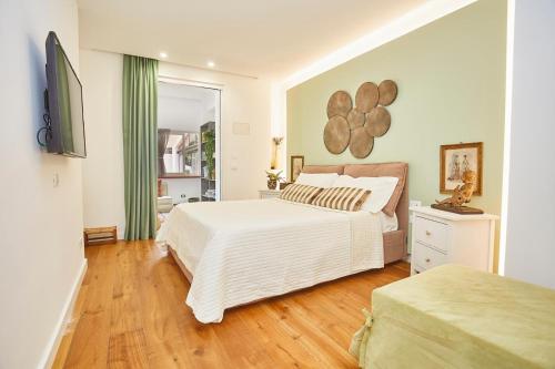 een slaapkamer met een wit bed en een televisie bij Villa Emma in Palermo