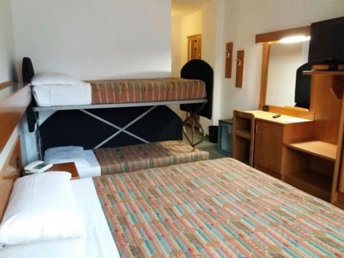 a room with two bunk beds and a desk at Liberty Hotel Malé in Malè