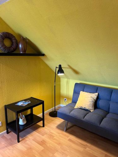 a living room with a blue couch and a table at Meerblick Cafe Reiten Spielplätze Animation WLAN in Fanø