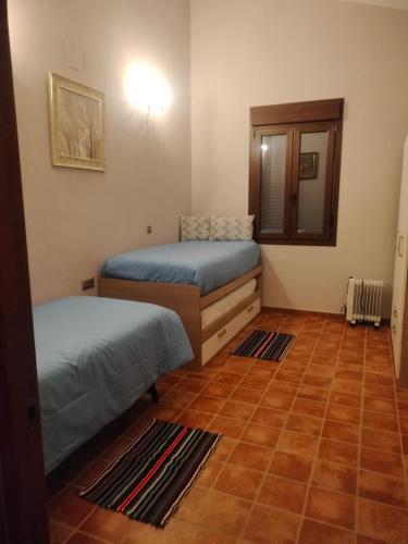 a room with two beds and a mirror at Casa Dehesa La Lancha in Cumbres Mayores