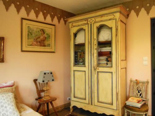 a large wooden cabinet in a corner of a room at Les Bains Bed & Breakfast in Cheny