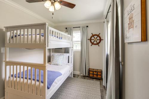 a bedroom with two bunk beds and a ceiling fan at Bring Your Boat Retreat Near Lake Guntersville in Guntersville