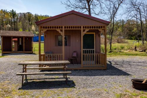een kleine hut met een picknicktafel en een bank bij Cozy Cabin3 Within Campground in Mifflinburg