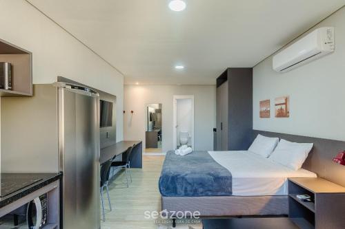 a hotel room with a bed and a kitchen at TCO - Apartamentos no Centro Histórico Porto Alegre/RS in Porto Alegre