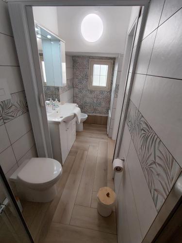 a bathroom with a toilet and a sink and a mirror at La casa di Zucchero in Monreale