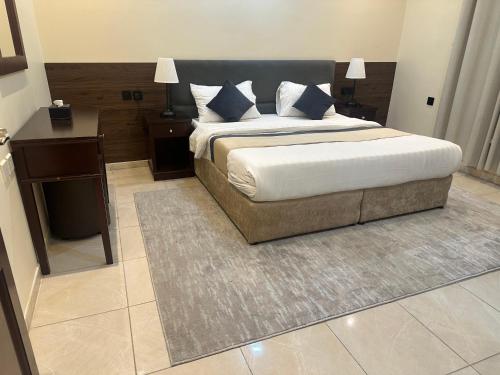 a bedroom with a bed and a nightstand and a bed sidx sidx sidx sidx at خيال الفارس للشقق المخدومة in Quwayzah
